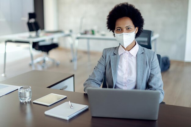 African American businesswoman wearing face mask while working on a computer in the office