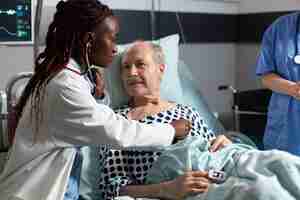 Free photo african american cardiologist checking examining senior patient heart