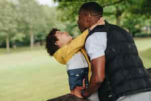 Free photo african-american child and his father playing in the park