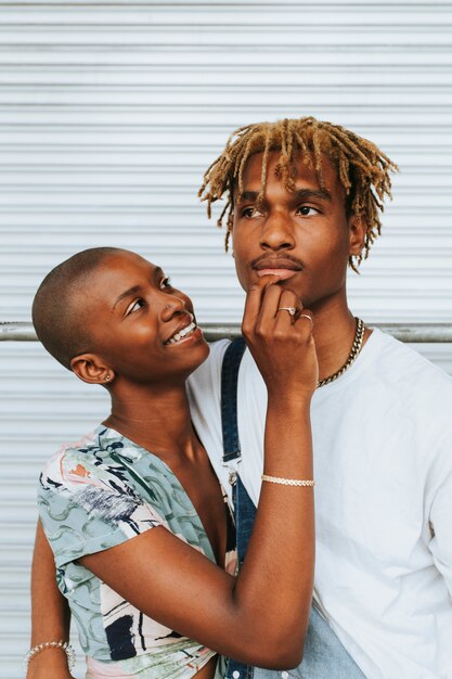 African american couple posing by a wall