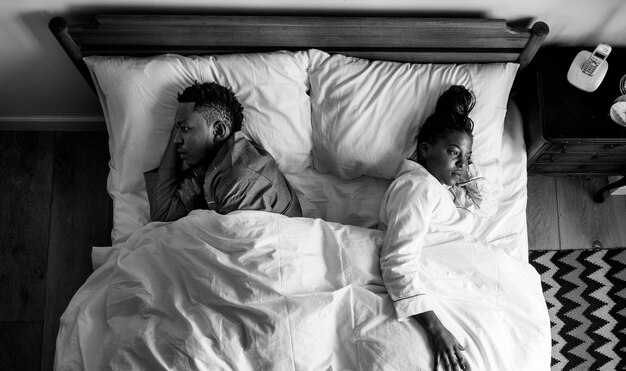 African American couple sleeping back to back