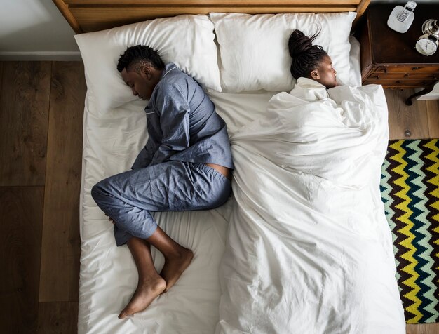 背中合わせ​に​寝ている​アフリカ系​アメリカ人​の​カップル