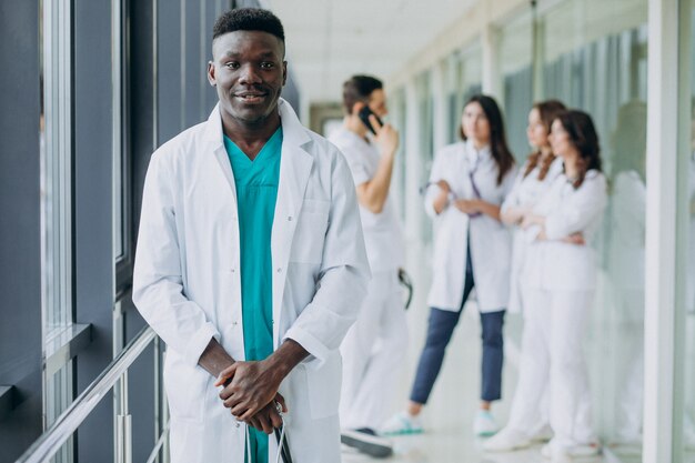 病院の廊下に立っているアフリカ系アメリカ人の医者の男