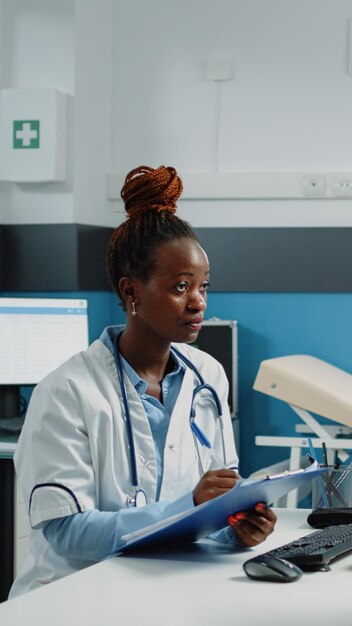 African american doctor and patient doing consultation for treatment against disease. Woman explaining pain and sickness to medic at annual checkup visit. Black people at examination