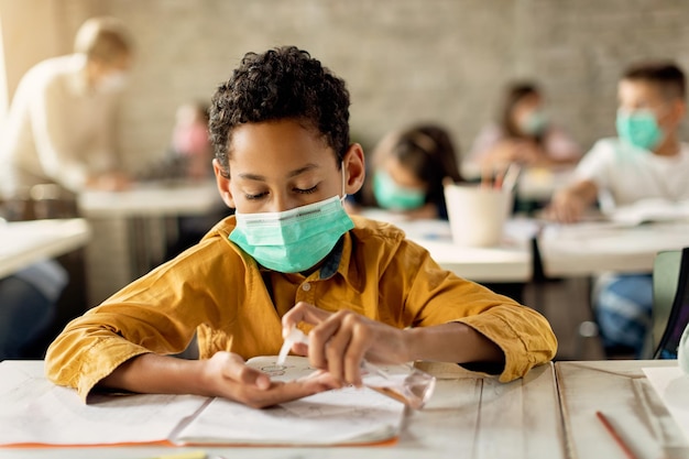 African American elementary student disinfecting hands in the classroom