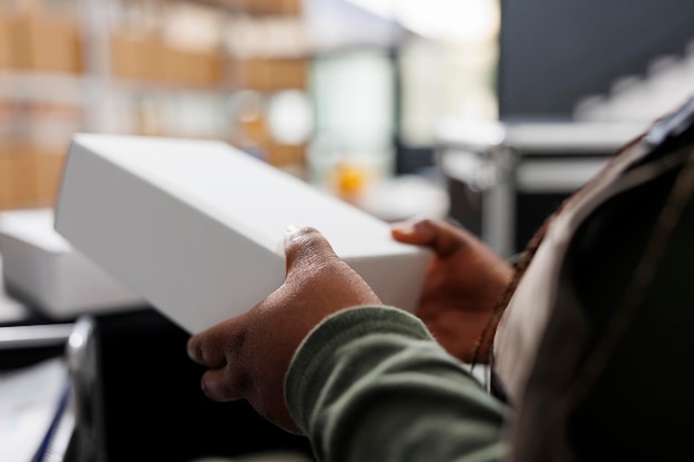 Free photo african american employee holding white cardboard boxes preparing packages for shipping in storehouse storage room worker wearing industrial overall working at customers orders in warehouse