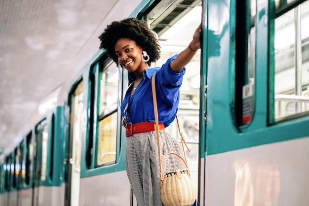 Donna afroamericana appesa alla porta di un treno