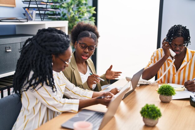 African american friends business workers sitting on table working at office