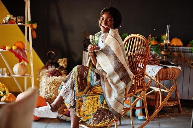 가을 분위기 장식에 대해 흔들의자에 앉아 있는 아프리카계 미국인 소녀 아프리카의 가을