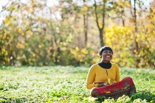 African american girl at yellow and red dress at autumn fall park