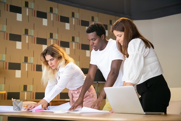 Ragazzo afroamericano e donne caucasiche che lavorano al design