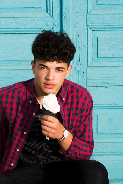 African American guy in checkered shirt holding ice cream 