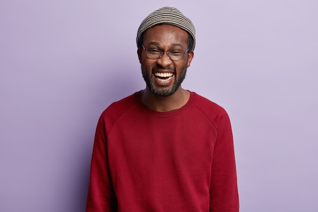 Ragazzo afroamericano che indossa camicia rossa e cappello alla moda