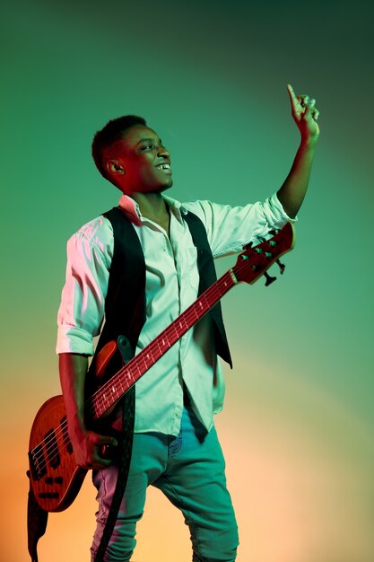 African American handsome jazz musician holding bass guitar and welcomes the audience