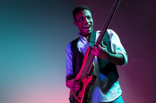 Афро-американский джазовый музыкант играет на бас-гитаре