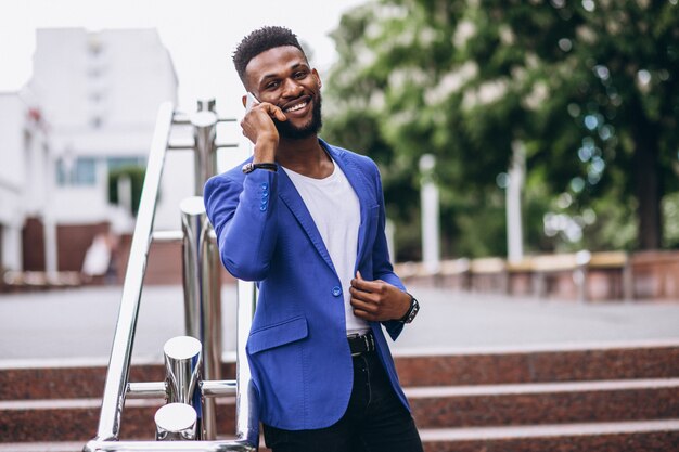 African american man in blue jacket using phone