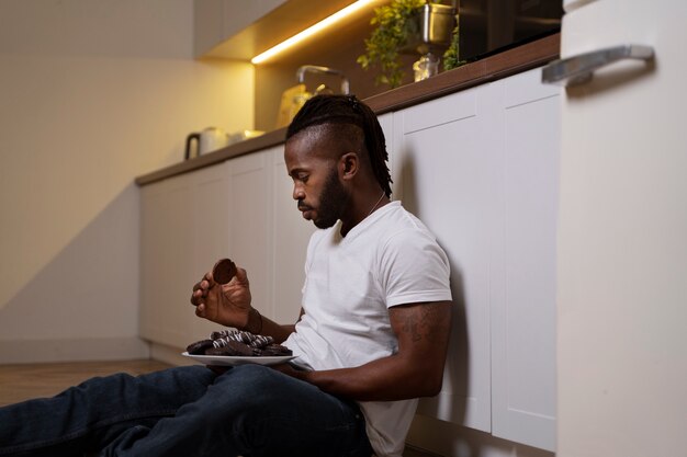 床で食べるアフリカ系アメリカ人の男