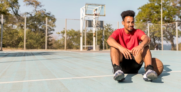バスケットボールの試合の後に休憩をとっているアフリカ系アメリカ人の男