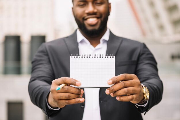 African-American man holding blank notebook