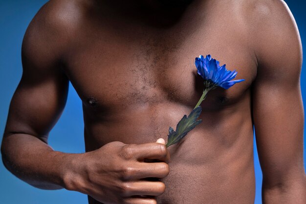 African american man holding a blue flower