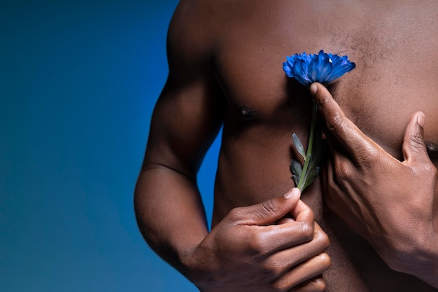 African american man holding a blue flower