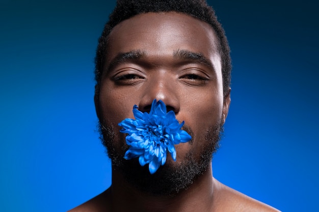 青い花を持っているアフリカ系アメリカ人の男
