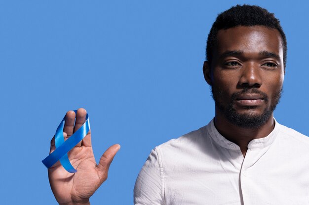 African american man holding a blue ribbon