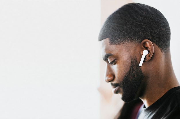 African american man listening to music on wireless earphones