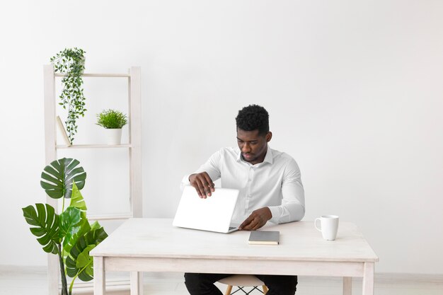 Афро-американский мужчина открывает ноутбук