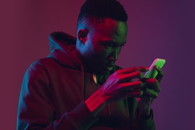 African-american man's portrait isolated on gradient wall in neon light