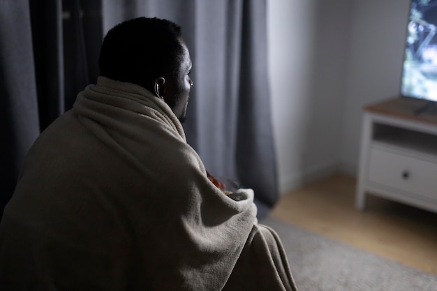 african american man watching streaming service at home alone