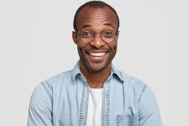 African-American man wearing round glasses and denim shirt