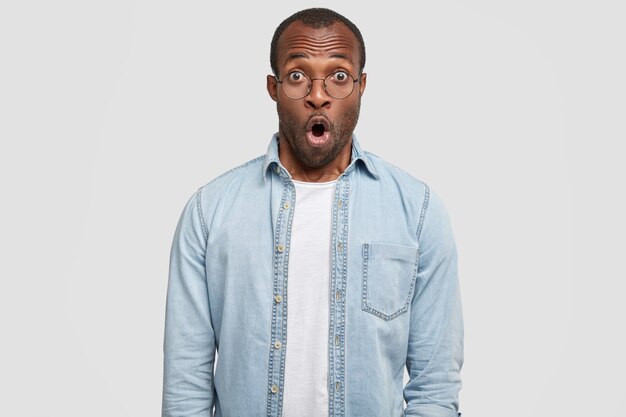 African-American man wearing round glasses and denim shirt