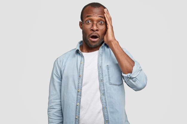 African-American man wearing round glasses and denim shirt