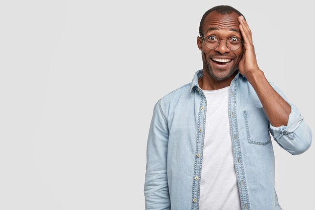 African-American man wearing round glasses and denim shirt