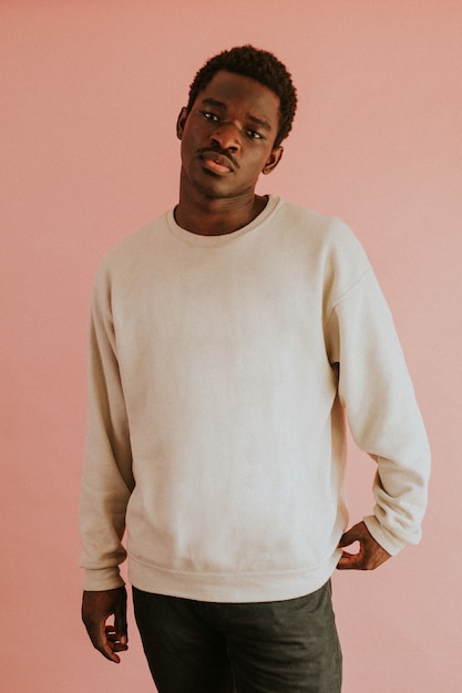 분홍색 배경에 흰색 스웨터를 입고 아프리카 계 미국인 남자