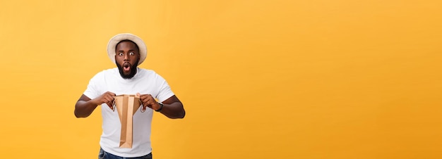 Афро-американский человек с красочными бумажных мешков, изолированных на желтом фоне