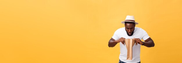 African american man with colorful paper bags isolated on yellow background