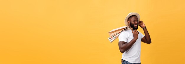 African American man with colorful paper bags isolated on yellow background