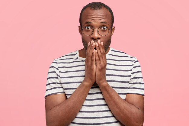 African-American man with round glasses and striped T-shirt