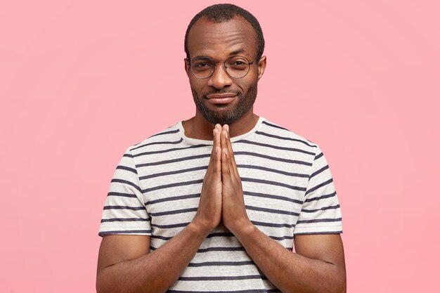 African-American man with round glasses and striped T-shirt