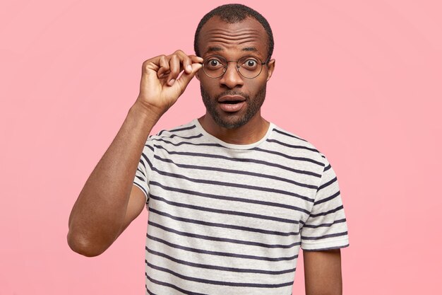 African-American man with round glasses and striped T-shirt