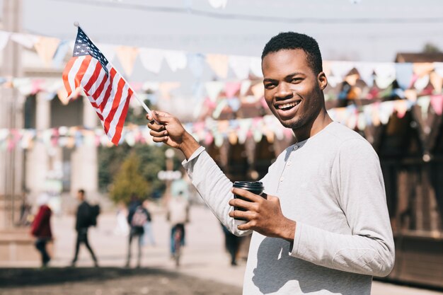 祭りにアメリカ国旗を持つアフリカ系アメリカ人の男