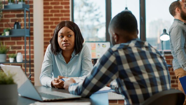 African american man and woman attendng job interview, having conversation about hiring selection and work application. Office worker interviewing female candidate about job offer.