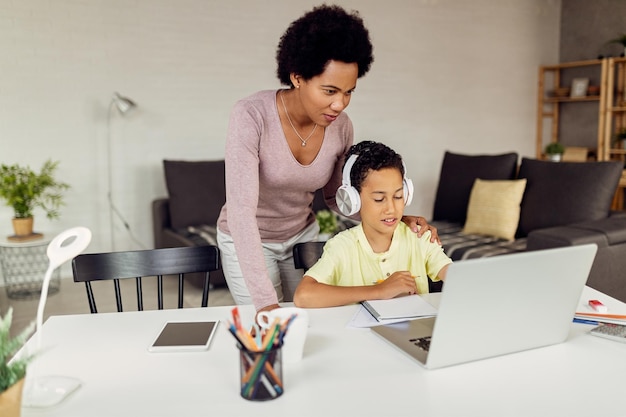 African American mother assisting her son in elearning at home