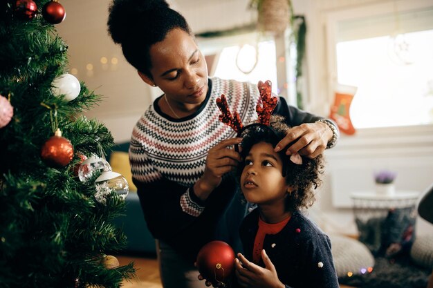 家でクリスマスの準備をしているアフリカ系アメリカ人の母と娘