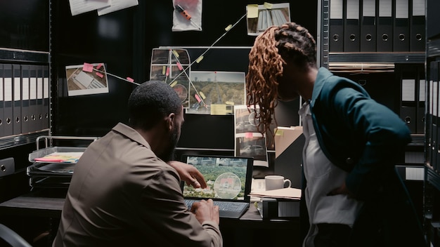 Free photo african american officers examining criminal records in incident room, planning private investigation in police archive. man and woman investors analyzing case files, reading statements.