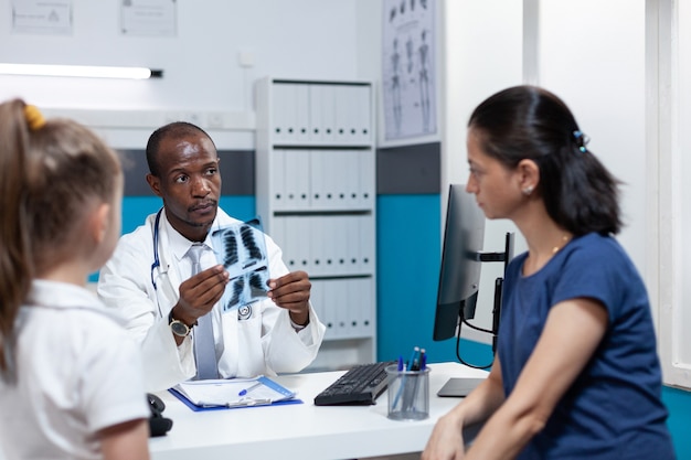 African american radiologist doctor disucssing healthcare treatment with patient mother