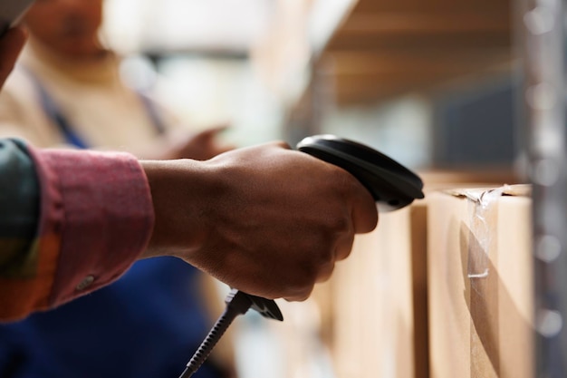 African american storehouse employee arm using barcode scanner