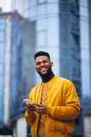 Free photo african american student walking in the street and talking on the phone